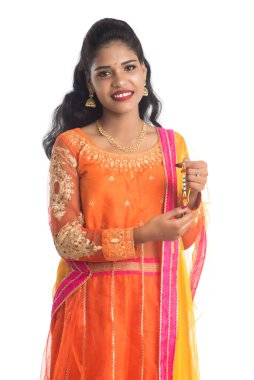 Raksha Bandhan vesilesiyle güzel Hintli kız Rakhi 'yi gösteriyor. Kız kardeş Rakhi 'yi erkek kardeşine olan yoğun sevgisinin sembolü olarak bağlıyor..