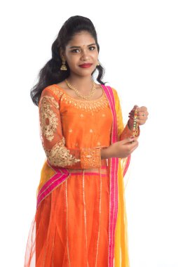 Raksha Bandhan vesilesiyle güzel Hintli kız Rakhi 'yi gösteriyor. Kız kardeş Rakhi 'yi erkek kardeşine olan yoğun sevgisinin sembolü olarak bağlıyor..