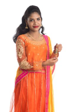 Raksha Bandhan vesilesiyle güzel Hintli kız Rakhi 'yi gösteriyor. Kız kardeş Rakhi 'yi erkek kardeşine olan yoğun sevgisinin sembolü olarak bağlıyor..