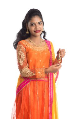 Raksha Bandhan vesilesiyle güzel Hintli kız Rakhi 'yi gösteriyor. Kız kardeş Rakhi 'yi erkek kardeşine olan yoğun sevgisinin sembolü olarak bağlıyor..