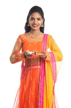 Güzel Hintli genç kız elinde pooja thali tutarken ya da beyaz bir arka planda ibadet ederken