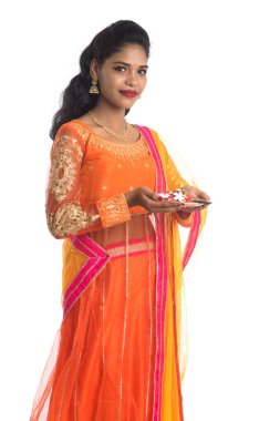 Güzel Hintli genç kız elinde pooja thali tutarken ya da beyaz bir arka planda ibadet ederken