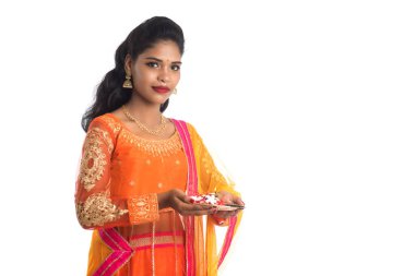 Güzel Hintli genç kız elinde pooja thali tutarken ya da beyaz bir arka planda ibadet ederken