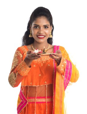 Güzel Hintli genç kız elinde pooja thali tutarken ya da beyaz bir arka planda ibadet ederken