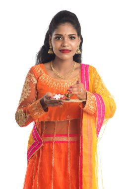 Güzel Hintli genç kız elinde pooja thali tutarken ya da beyaz bir arka planda ibadet ederken