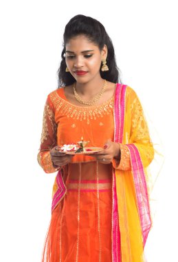 Güzel Hintli genç kız elinde pooja thali tutarken ya da beyaz bir arka planda ibadet ederken