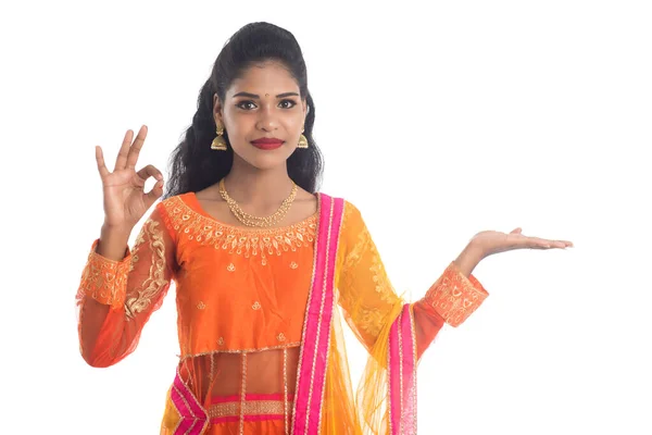 明るいインドの伝統的な若い女性の肖像画は 白い背景に彼女の手のひらにコピースペースを示し 手に何かを提示 — ストック写真