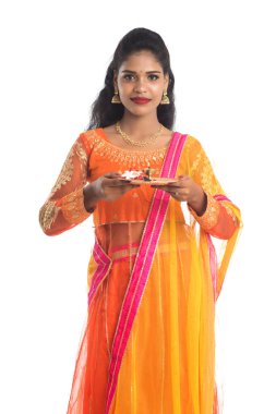 Güzel Hintli genç kız elinde pooja thali tutarken ya da beyaz bir arka planda ibadet ederken