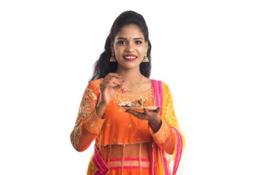 Güzel Hintli genç kız elinde pooja thali tutarken ya da beyaz bir arka planda ibadet ederken