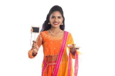Raksha Bandhan vesilesiyle Rakhi 'ye pooja thali ve kara tahtayla güzel bir Hintli kız gösteriyordu. Kız kardeş Rakhi 'yi erkek kardeşine olan yoğun sevgisinin sembolü olarak bağlıyor..