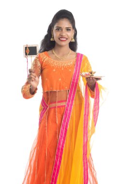 Raksha Bandhan vesilesiyle Rakhi 'ye pooja thali ve kara tahtayla güzel bir Hintli kız gösteriyordu. Kız kardeş Rakhi 'yi erkek kardeşine olan yoğun sevgisinin sembolü olarak bağlıyor..