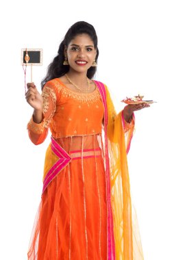 Raksha Bandhan vesilesiyle Rakhi 'ye pooja thali ve kara tahtayla güzel bir Hintli kız gösteriyordu. Kız kardeş Rakhi 'yi erkek kardeşine olan yoğun sevgisinin sembolü olarak bağlıyor..