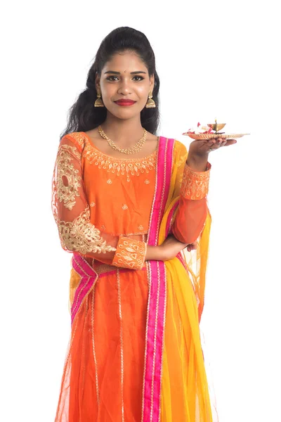 Güzel Hintli genç kız elinde pooja thali tutarken ya da beyaz bir arka planda ibadet ederken