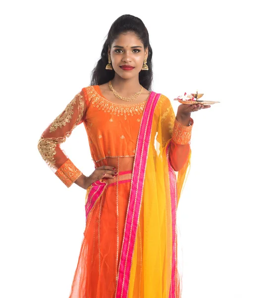 Güzel Hintli genç kız elinde pooja thali tutarken ya da beyaz bir arka planda ibadet ederken