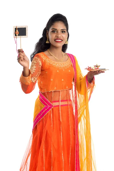 Raksha Bandhan vesilesiyle Rakhi 'ye pooja thali ve kara tahtayla güzel bir Hintli kız gösteriyordu. Kız kardeş Rakhi 'yi erkek kardeşine olan yoğun sevgisinin sembolü olarak bağlıyor..