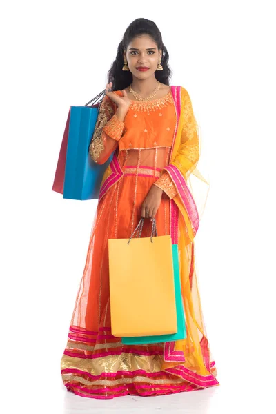 美しいインドの若い女の子は 伝統的な民族服を着て買い物袋を保持 白い背景に隔離された — ストック写真