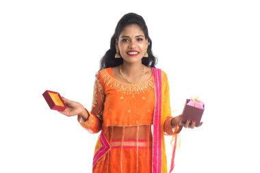 Beyaz bir arka planda hediye kutuları tutan mutlu Hintli genç kızın portresi..