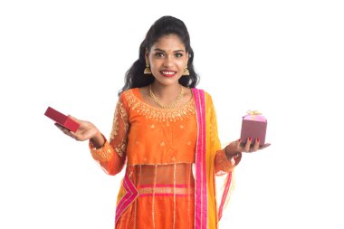Beyaz bir arka planda hediye kutuları tutan mutlu Hintli genç kızın portresi..