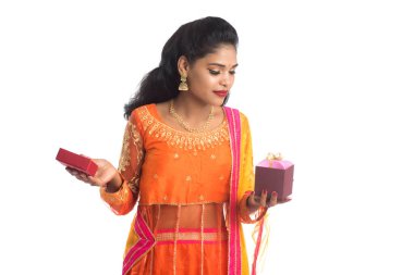 Beyaz bir arka planda hediye kutuları tutan mutlu Hintli genç kızın portresi..