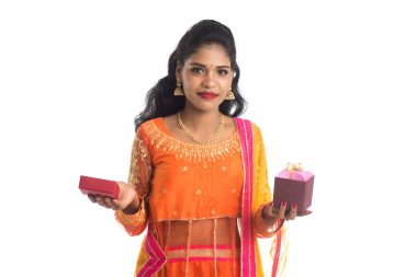 Beyaz bir arka planda hediye kutuları tutan mutlu Hintli genç kızın portresi..
