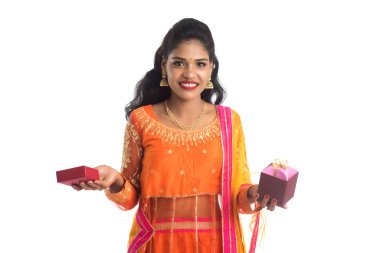 Beyaz bir arka planda hediye kutuları tutan mutlu Hintli genç kızın portresi..