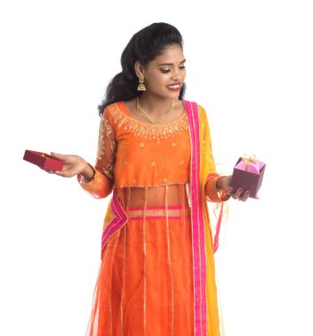 Beyaz bir arka planda hediye kutuları tutan mutlu Hintli genç kızın portresi..