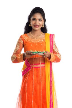 Beyaz arka planda ışık festivali sırasında Diya 'yı, Diwali' yi veya Deepavali 'yi kutlayan kızı tutan Hintli Geleneksel Kız Portresi