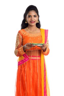 Beyaz arka planda ışık festivali sırasında Diya 'yı, Diwali' yi veya Deepavali 'yi kutlayan kızı tutan Hintli Geleneksel Kız Portresi