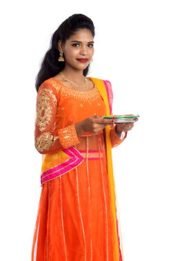 Beyaz arka planda ışık festivali sırasında Diya 'yı, Diwali' yi veya Deepavali 'yi kutlayan kızı tutan Hintli Geleneksel Kız Portresi