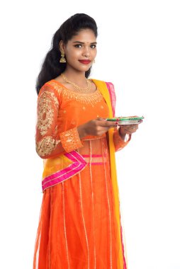 Beyaz arka planda ışık festivali sırasında Diya 'yı, Diwali' yi veya Deepavali 'yi kutlayan kızı tutan Hintli Geleneksel Kız Portresi