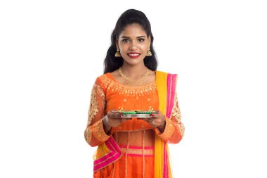 Beyaz arka planda ışık festivali sırasında Diya 'yı, Diwali' yi veya Deepavali 'yi kutlayan kızı tutan Hintli Geleneksel Kız Portresi