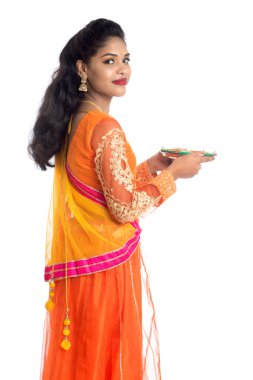 Beyaz arka planda ışık festivali sırasında Diya 'yı, Diwali' yi veya Deepavali 'yi kutlayan kızı tutan Hintli Geleneksel Kız Portresi