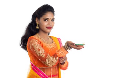 Beyaz arka planda ışık festivali sırasında Diya 'yı, Diwali' yi veya Deepavali 'yi kutlayan kızı tutan Hintli Geleneksel Kız Portresi