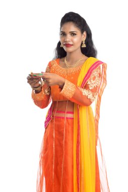 Beyaz arka planda ışık festivali sırasında Diya 'yı, Diwali' yi veya Deepavali 'yi kutlayan kızı tutan Hintli Geleneksel Kız Portresi