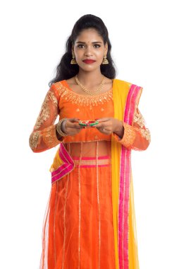 Beyaz arka planda ışık festivali sırasında Diya 'yı, Diwali' yi veya Deepavali 'yi kutlayan kızı tutan Hintli Geleneksel Kız Portresi