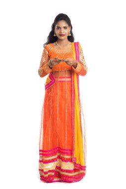 Beyaz arka planda ışık festivali sırasında Diya 'yı, Diwali' yi veya Deepavali 'yi kutlayan kızı tutan Hintli Geleneksel Kız Portresi