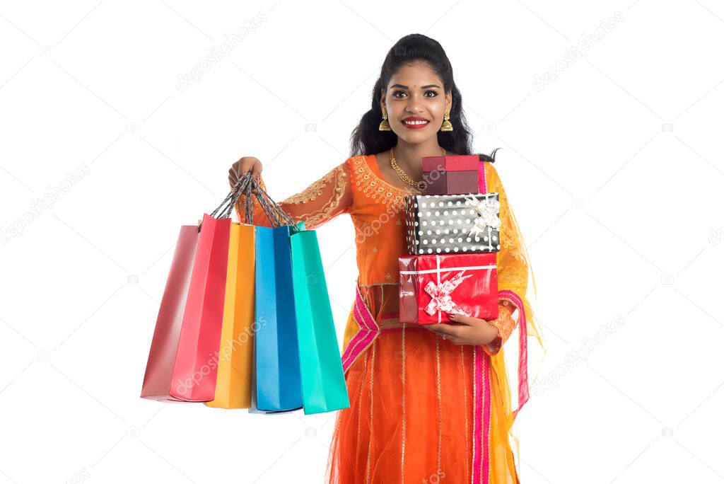 Beautiful woman carrying many shopping bags and gift Box on a white background.