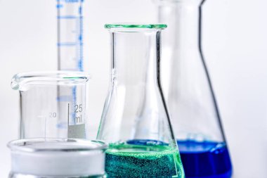 Laboratuar kapkacakları, yeşil ve mavi sıvı Erlenmeyer şişeler içinde