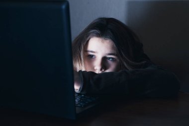 sad and female teenager with tablet computer and laptop suffering cyberbullying and harassment being online abused by stalker or gossip feeling desperate and humiliated in cyber bullying clipart