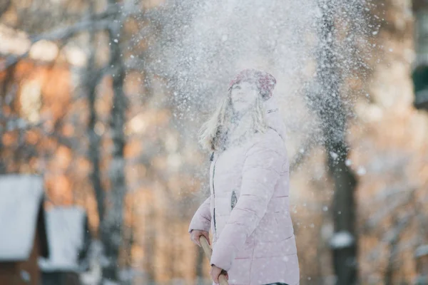 若い十代の少女をきれいに家の近くの雪シャベルとパドルを過ごす時間を保持 — ストック写真