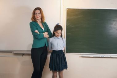 Yaşlı öğretmen öğrenci matematik dersine soran kara tahta yakınındaki gülümseyen