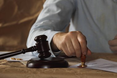 Erkek el bir alyans üzerinden boşanma kağıtlarını imzalamak üzere bir el için bastırıyor.