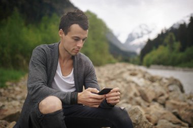 Telefonda Nehri'nin uçurumun üzerinde oturan genç şık adam