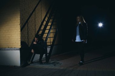 Siluet bir adamın bir kadını arkadan karanlık bir tünelde saldırır. Kadın kavramı karşı şiddet. kopya alanı