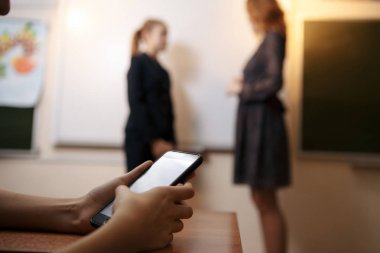 İlköğretim Okulu öğrenci kısa sınıfta cep telefonuyla mesaj