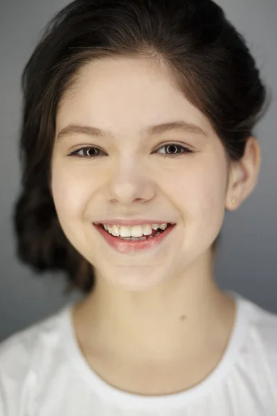 Drôle mignon jeune fille souriant clin d'oeil montrant la langue regardant caméra sur fond blanc . — Photo