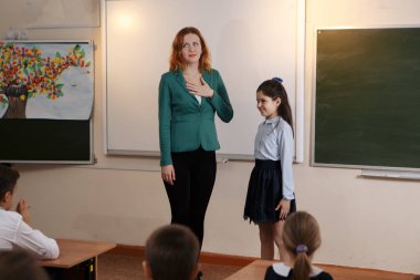 Yaşlı öğretmen öğrenci matematik dersine soran kara tahta yakınındaki gülümseyen