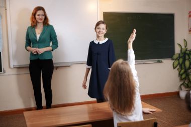 joven colegiala posando delante de un pizarrón