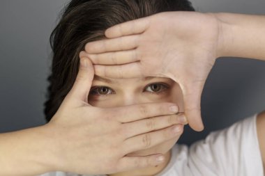 Kağıt delikten sürpriz gözetleme neşeli bir genç kız