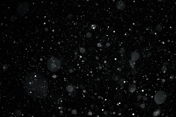 closeup background texture of snowflakes during a snowfall on a black background